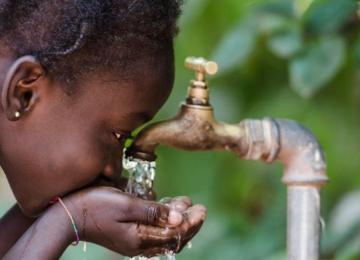 Une enfant buvant l'eau de la Regideso. Photo d'illustration 