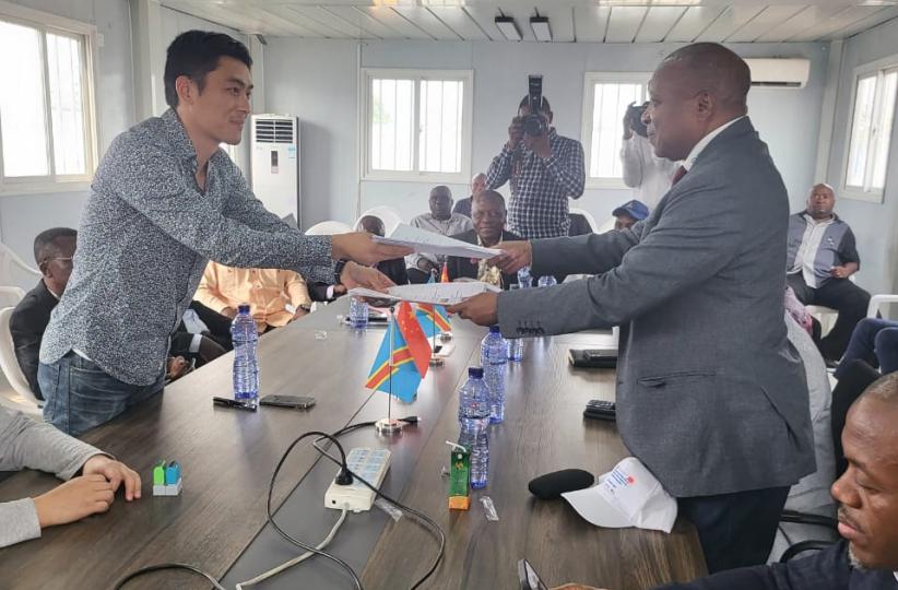 Remise et reprise entre le Représentant de Shanghai Electric, Vincent Qin, et le Directeur de la Coordination des grands projets (DGR), Léon Makwenge, en présence des délégués de la SNEL