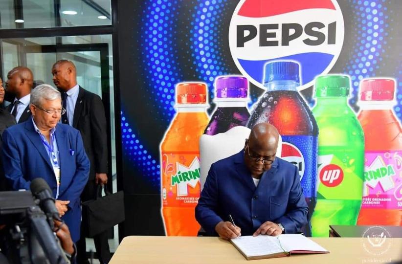 Le chef de l'État signant le livre d'or de la société PEPSI 